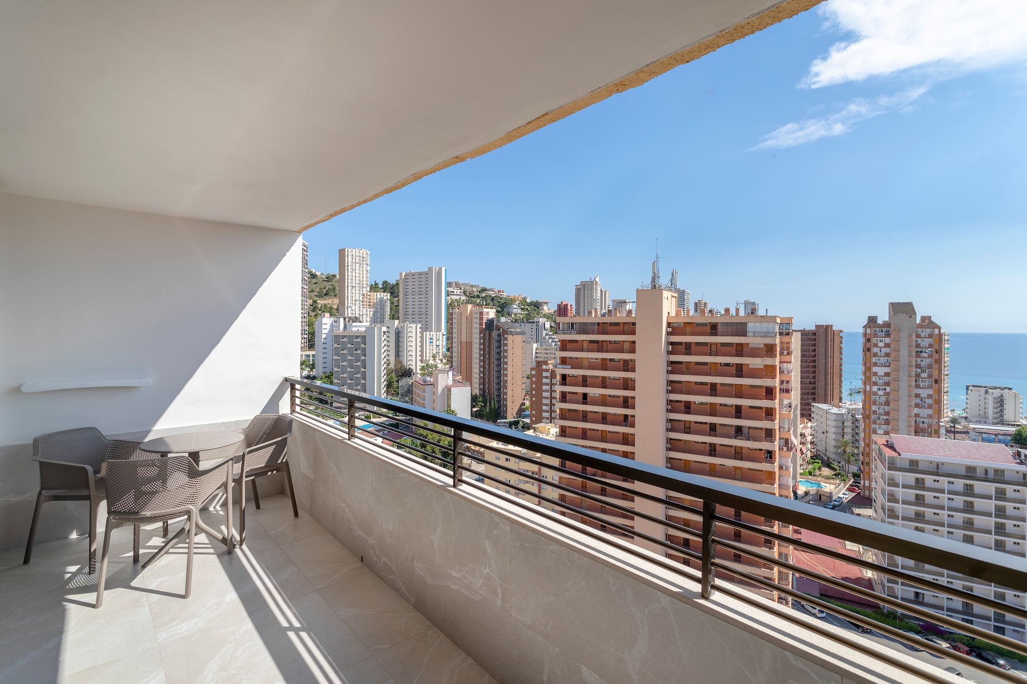 a balcony with chairs and a city view