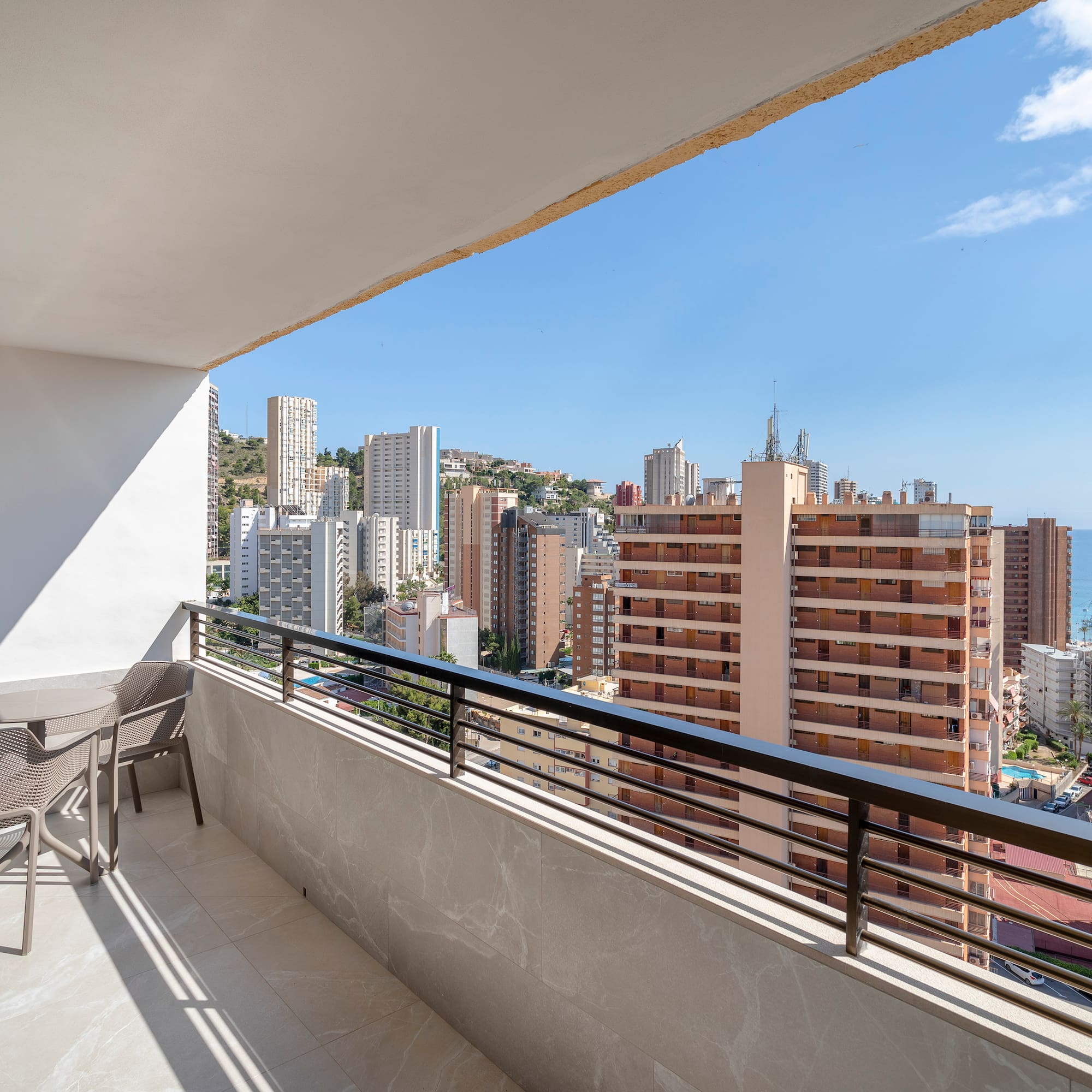 a balcony with chairs and a city view