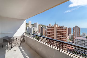 a balcony with chairs and a city view
