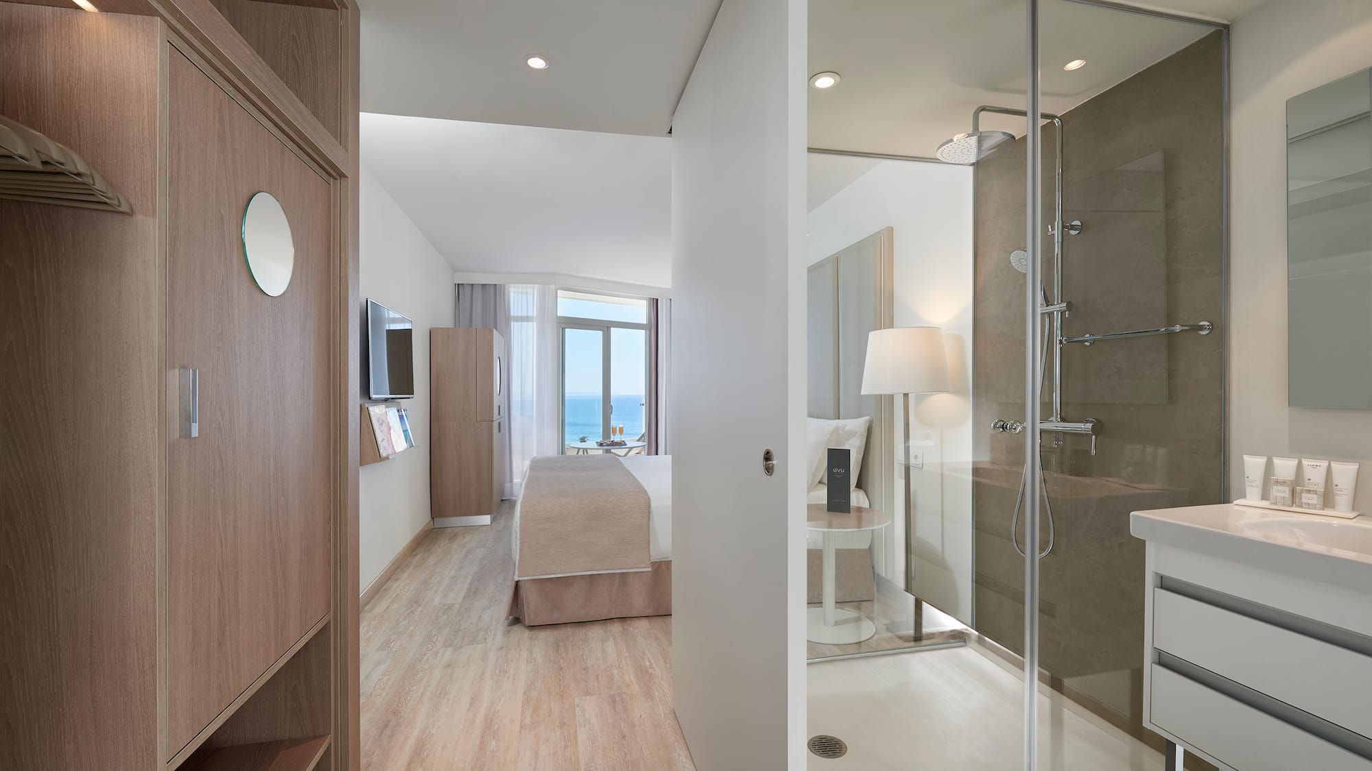 a bathroom with a glass shower and a bed