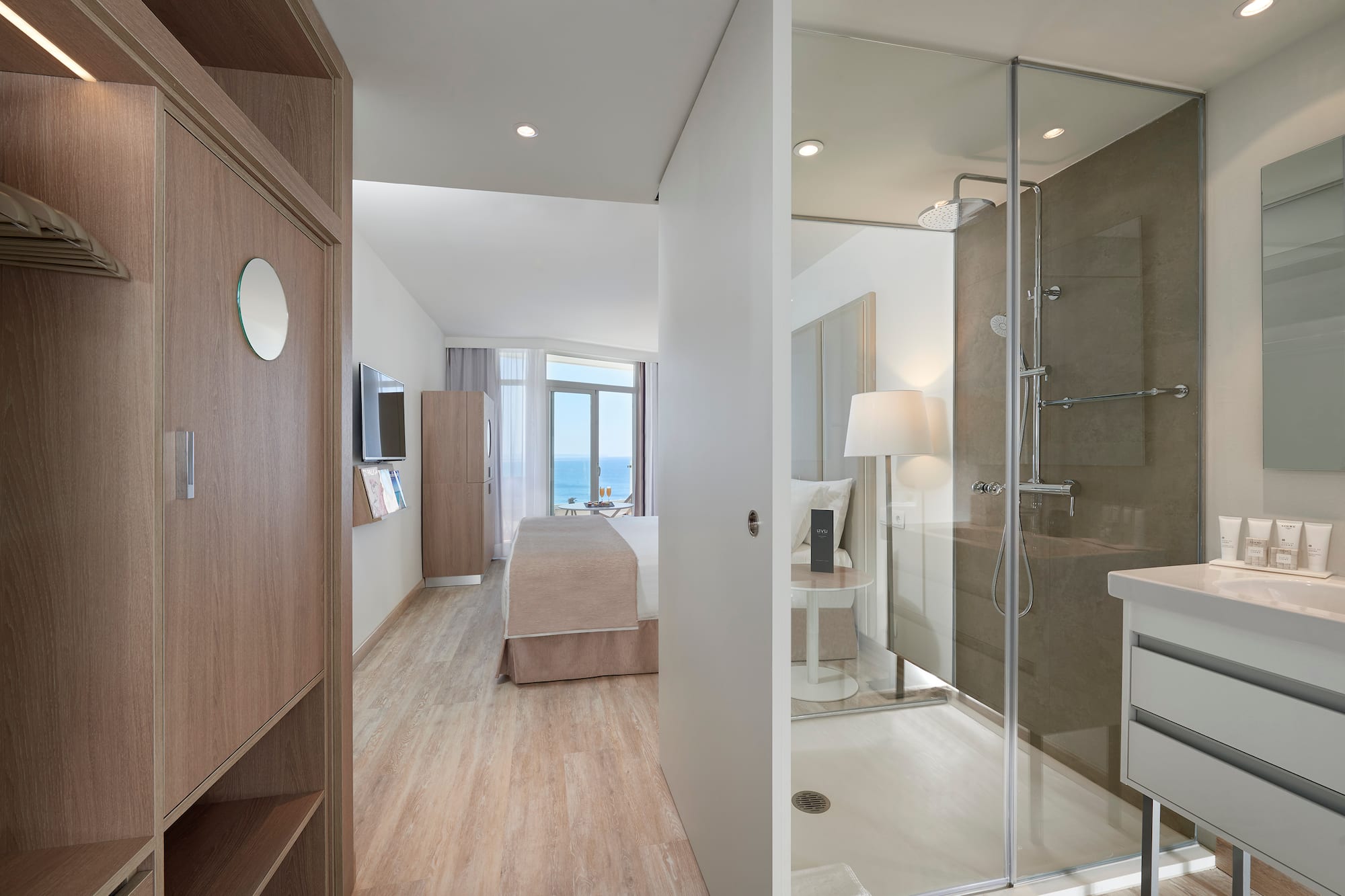 a bathroom with a glass shower and a bed