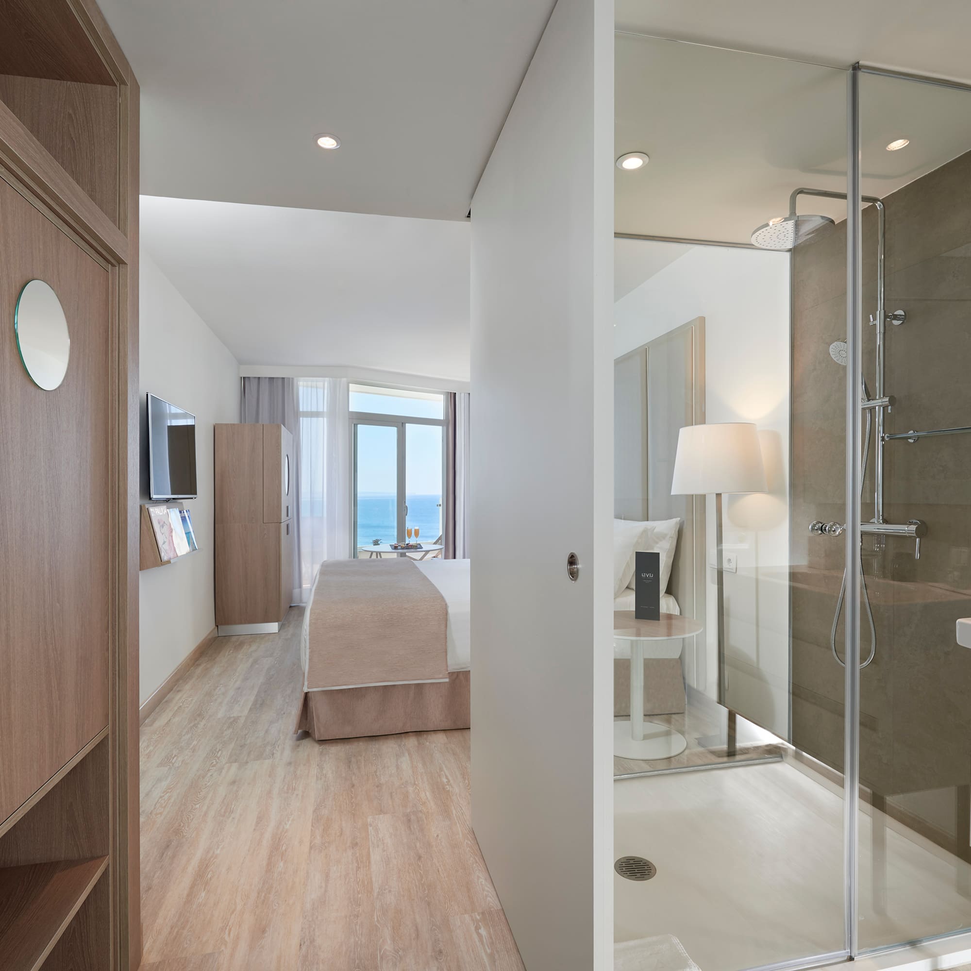 a bathroom with a glass shower and a bed