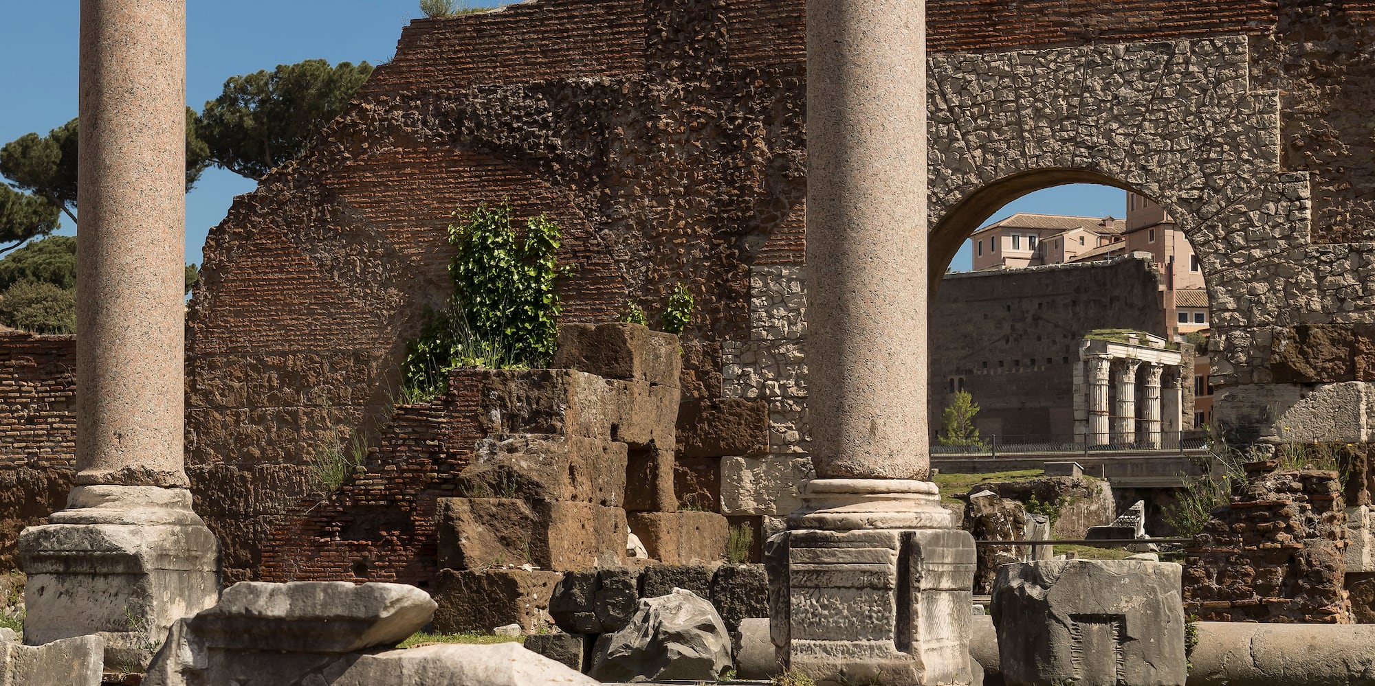 a stone ruins with columns and a stone arch