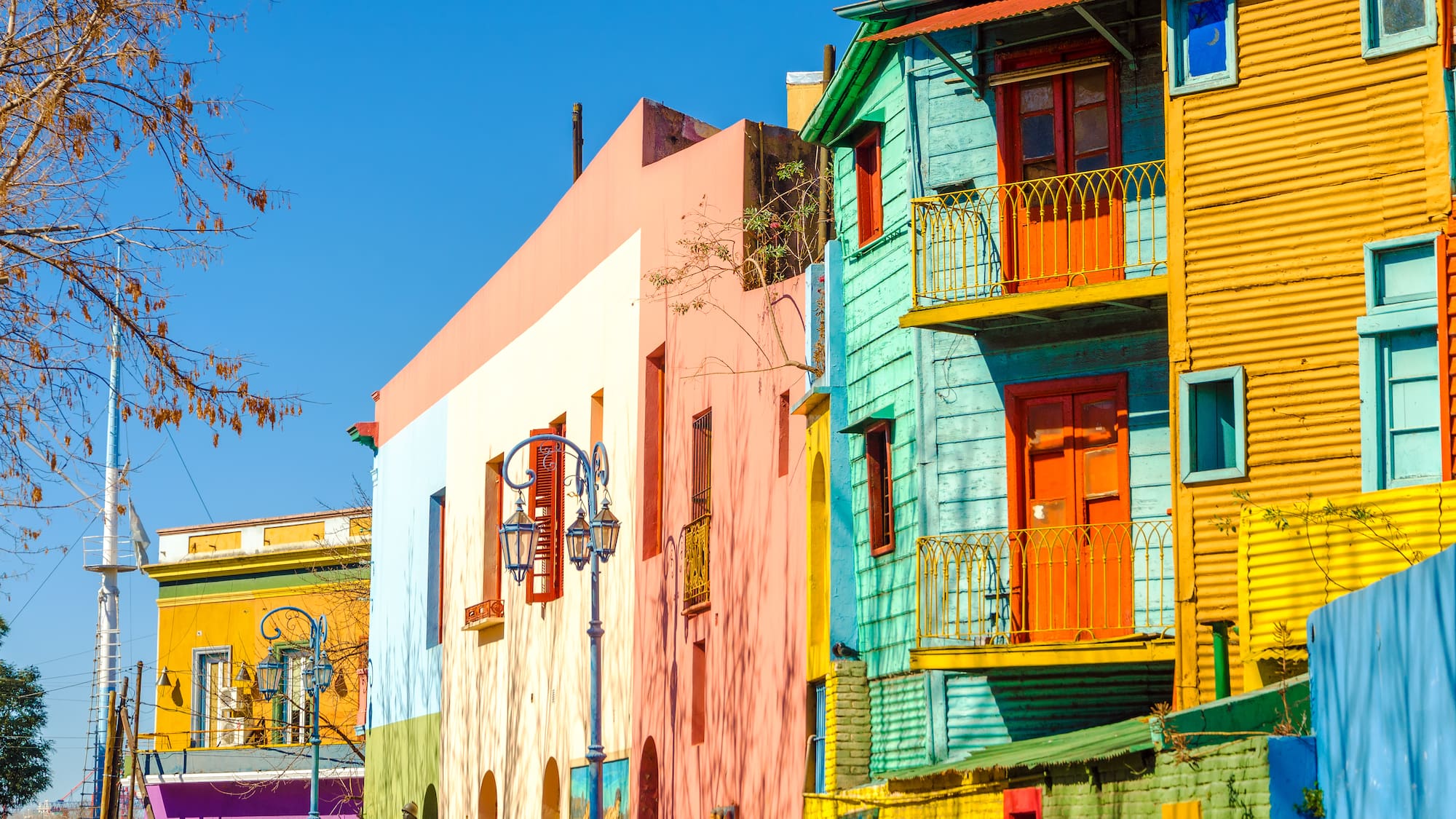 a colorful buildings on a street with La Boca in the background