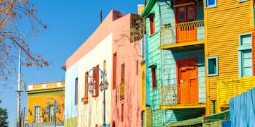 a colorful buildings on a street with La Boca in the background