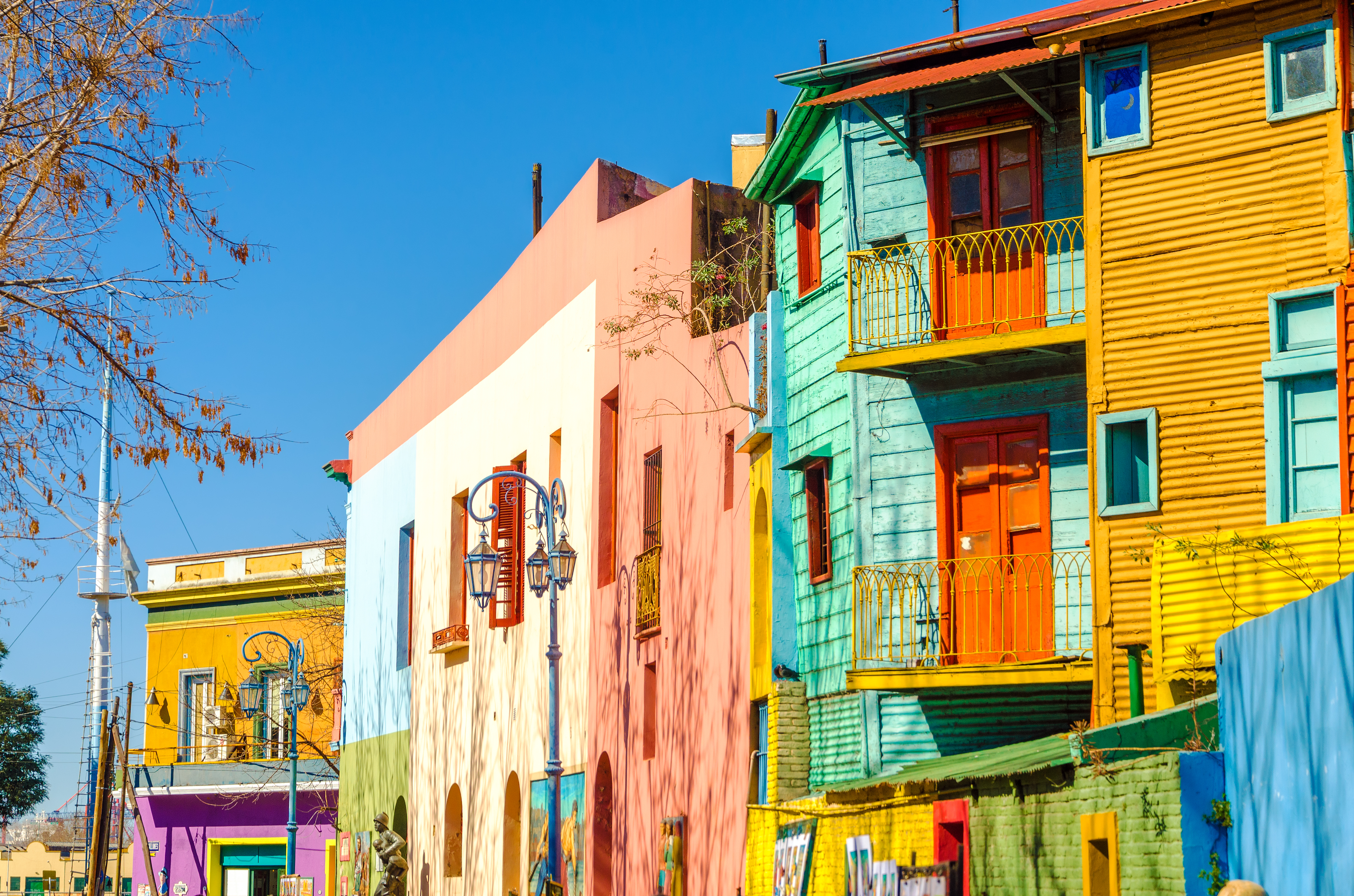 a colorful buildings on a street with La Boca in the background