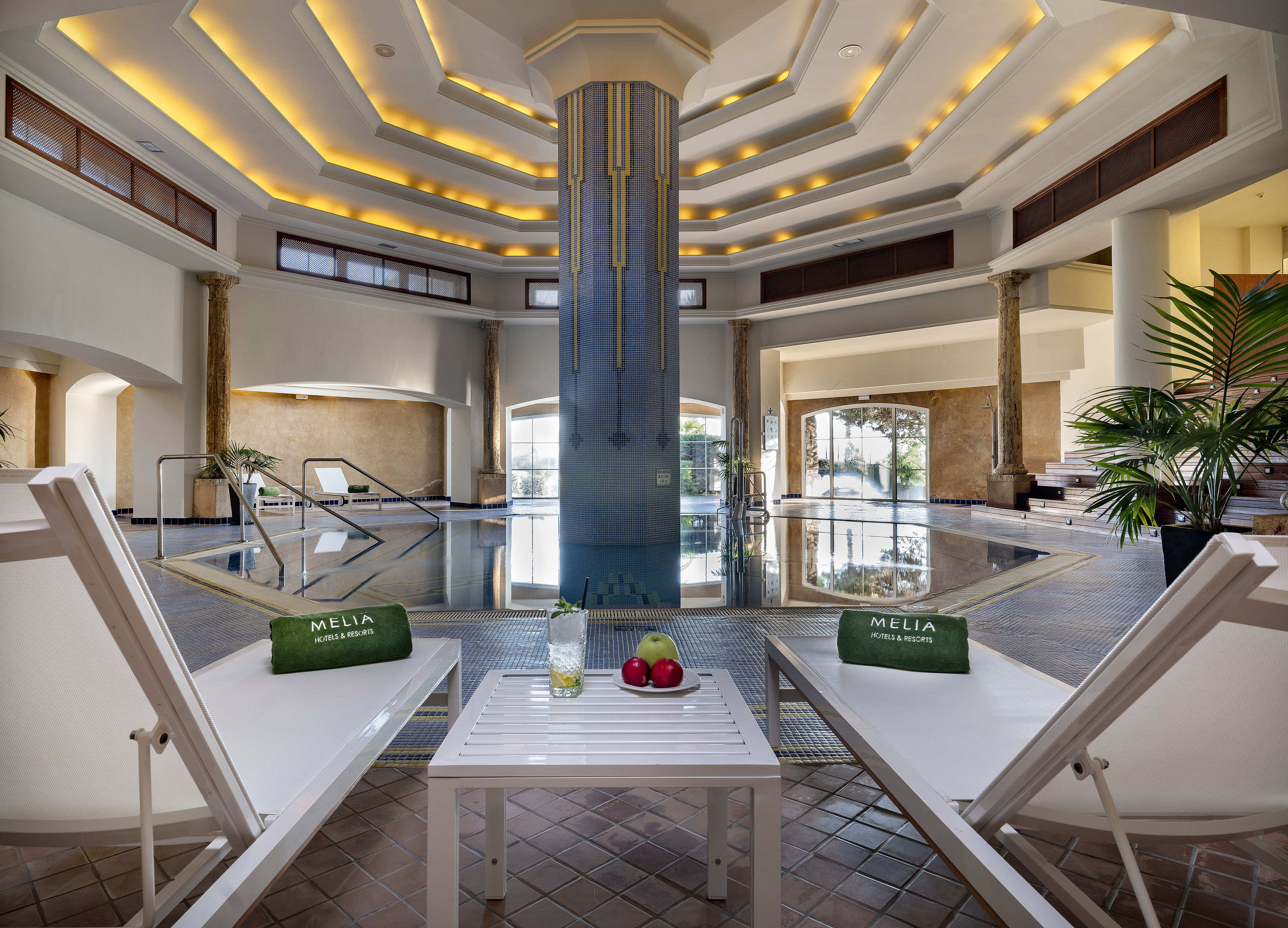 Meliá luxury indoor pool, spa with lounge chairs and drinks.