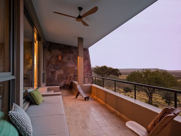 a balcony with a couch and a fan