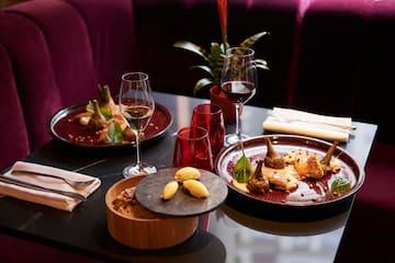 a table with plates of food and wine glasses