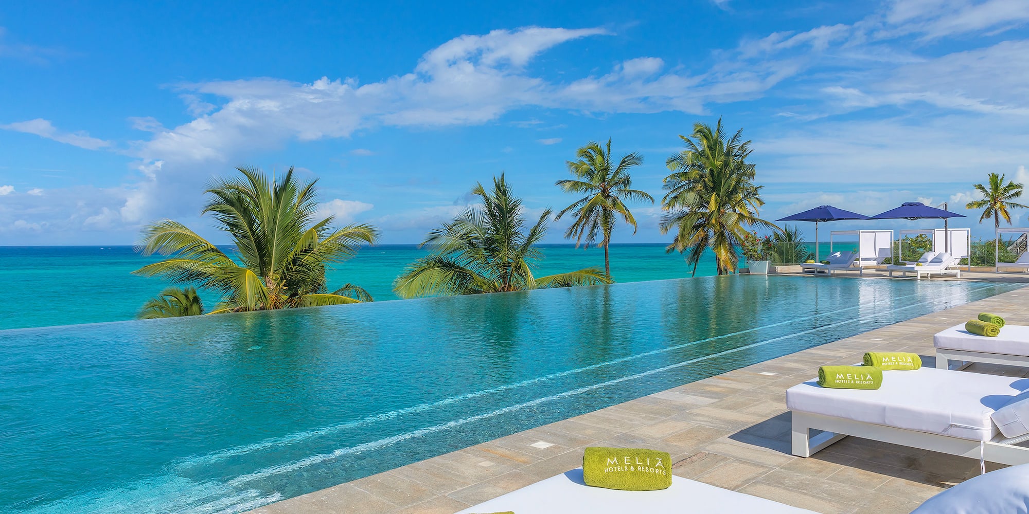 a pool with palm trees and a blue sky