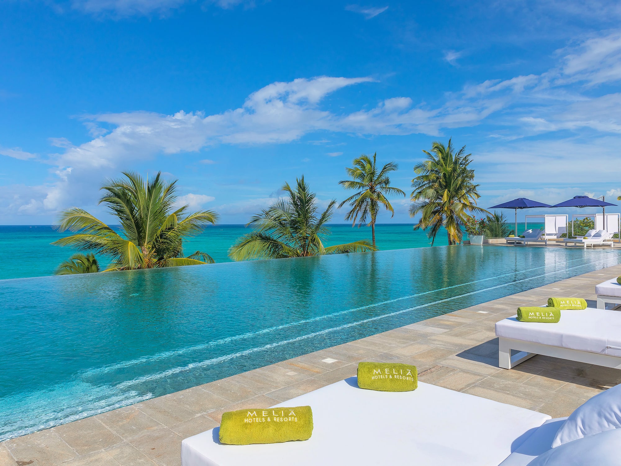 a pool with palm trees and a blue sky