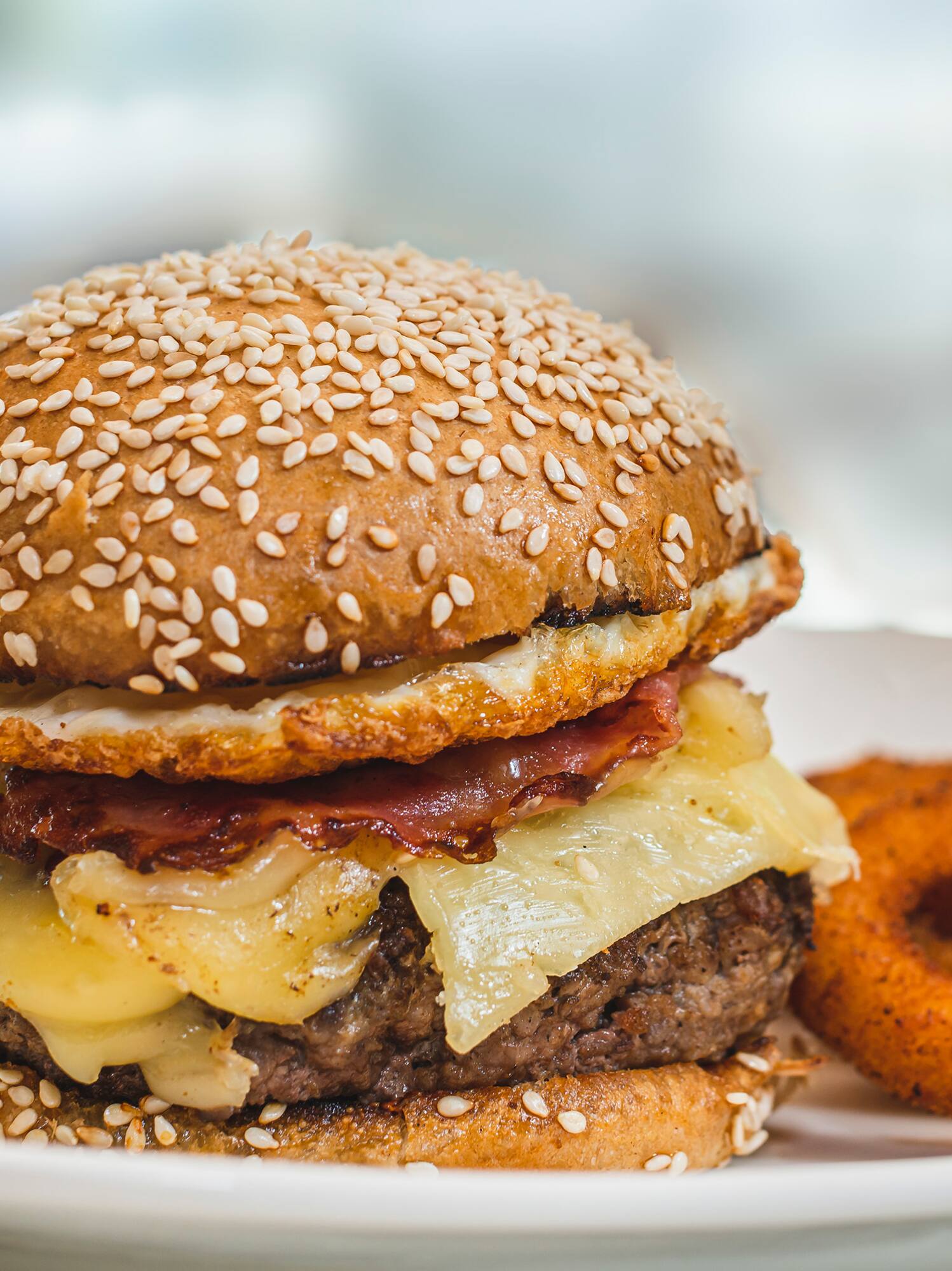 a cheeseburger with onion rings on a plate
