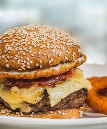 a cheeseburger with onion rings on a plate