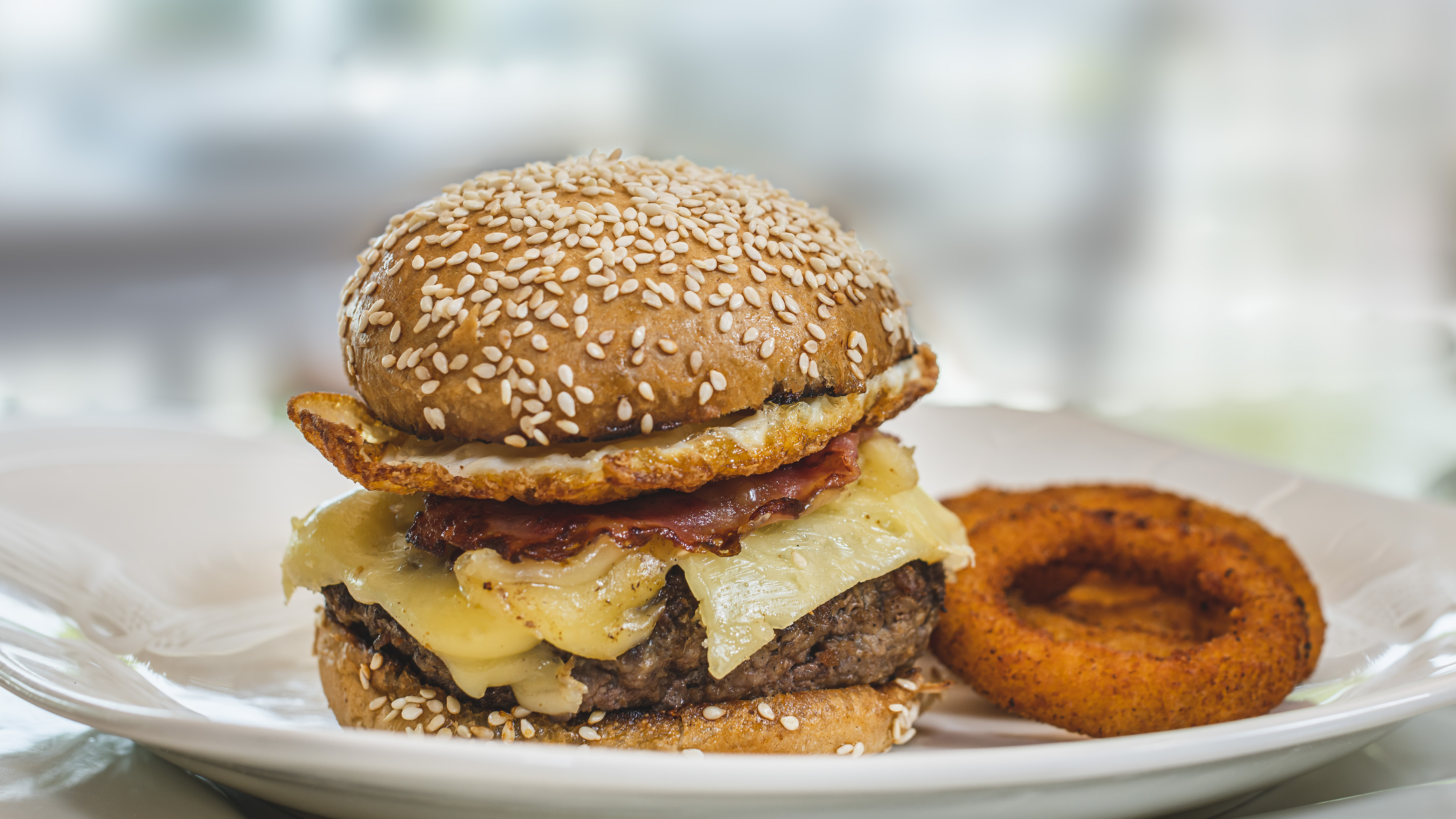a cheeseburger with onion rings on a plate