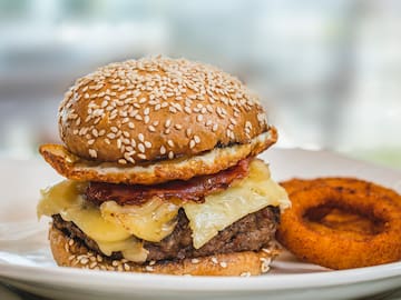 a cheeseburger with onion rings on a plate