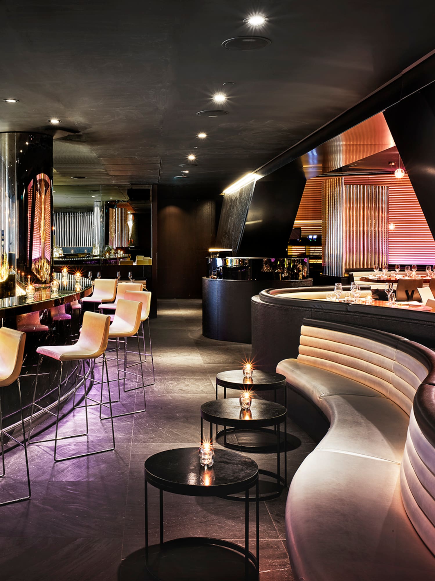 a room with a bar and a long curved bench