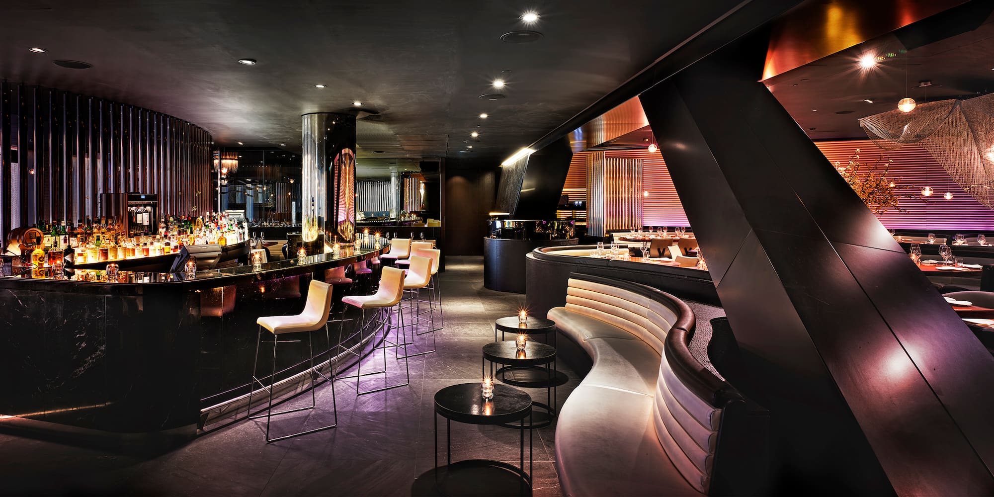 a room with a bar and a long curved bench