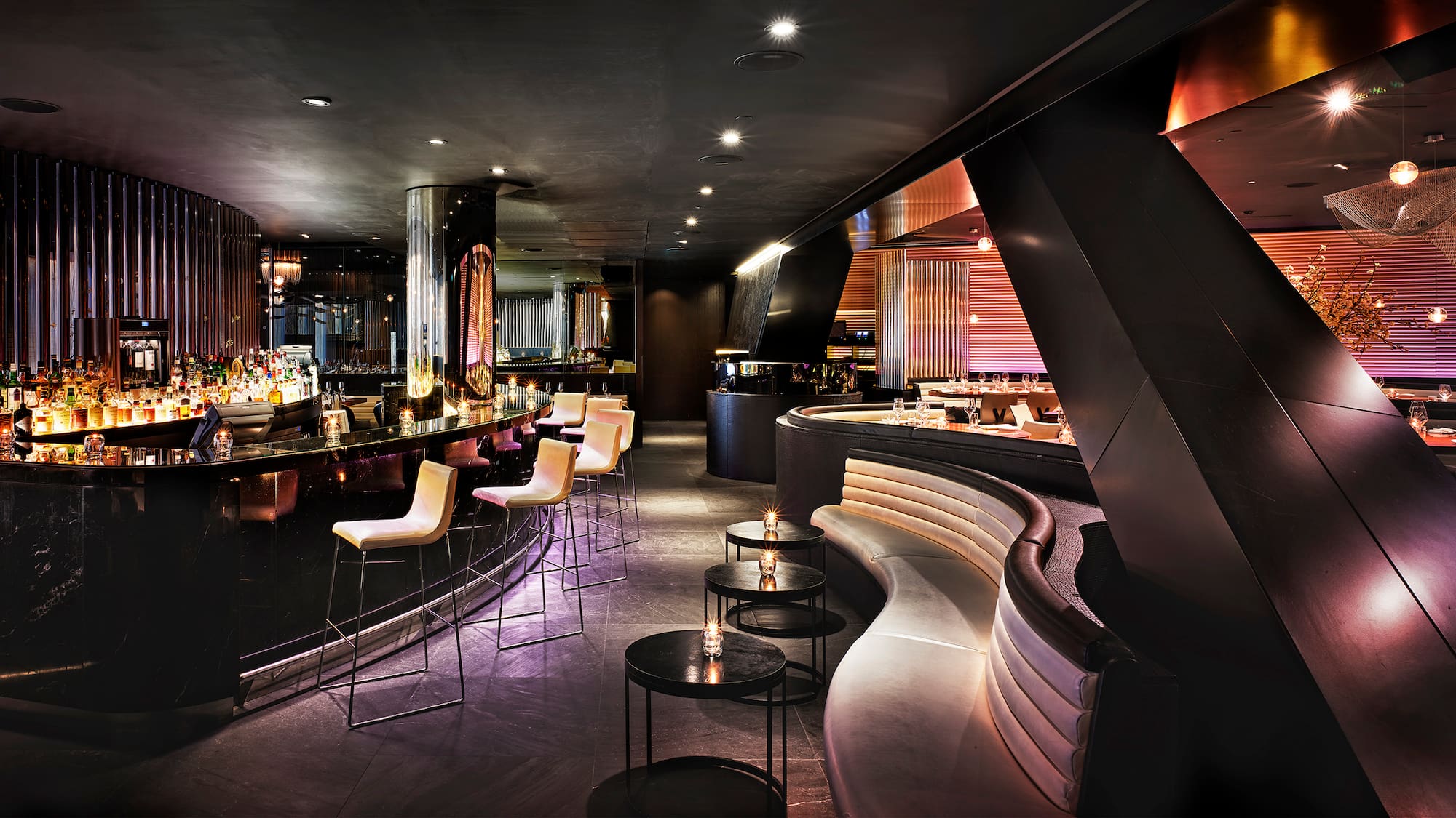 a room with a bar and a long curved bench