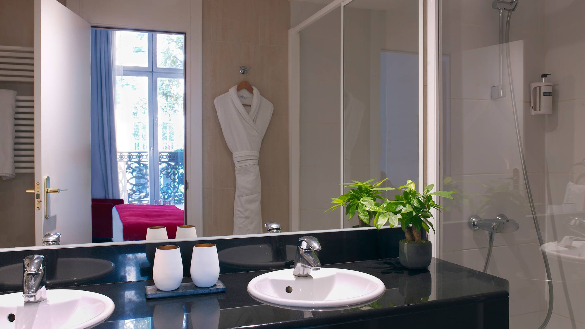 a bathroom with a black countertop and a white bathrobe