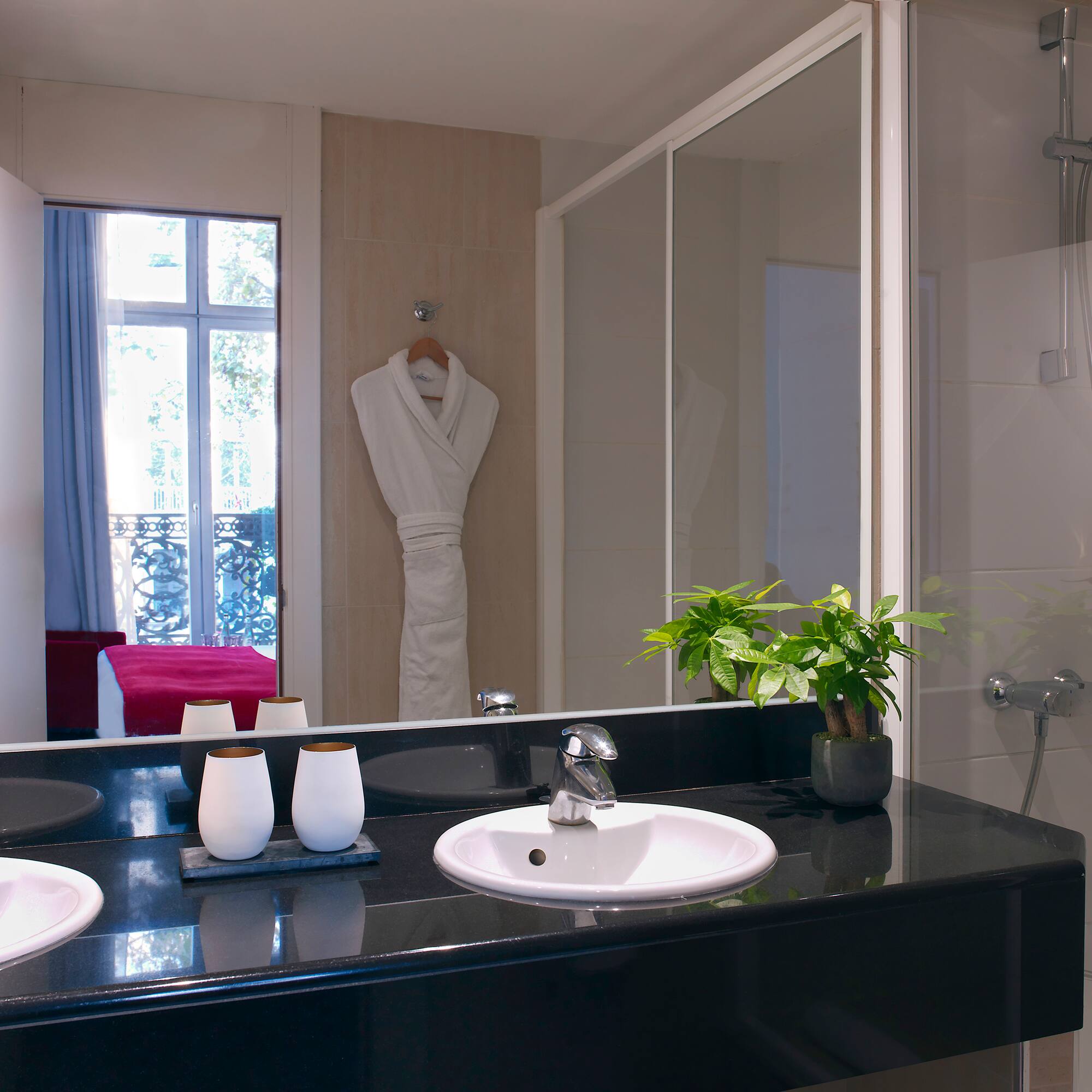 a bathroom with a black countertop and a white bathrobe
