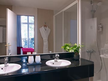 a bathroom with a black countertop and a white bathrobe
