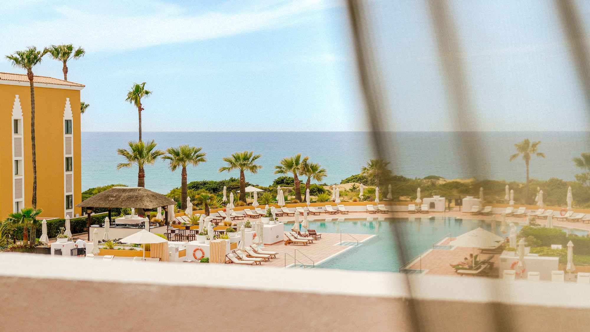 a pool with umbrellas and chairs and palm trees