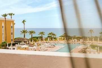a pool with umbrellas and chairs and palm trees
