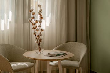 a table with a vase of cotton flowers and a book