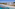 a beach with a building and a body of water