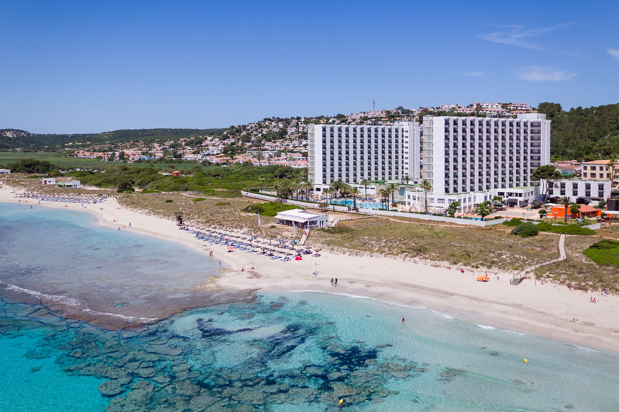 a beach with a building and a body of water