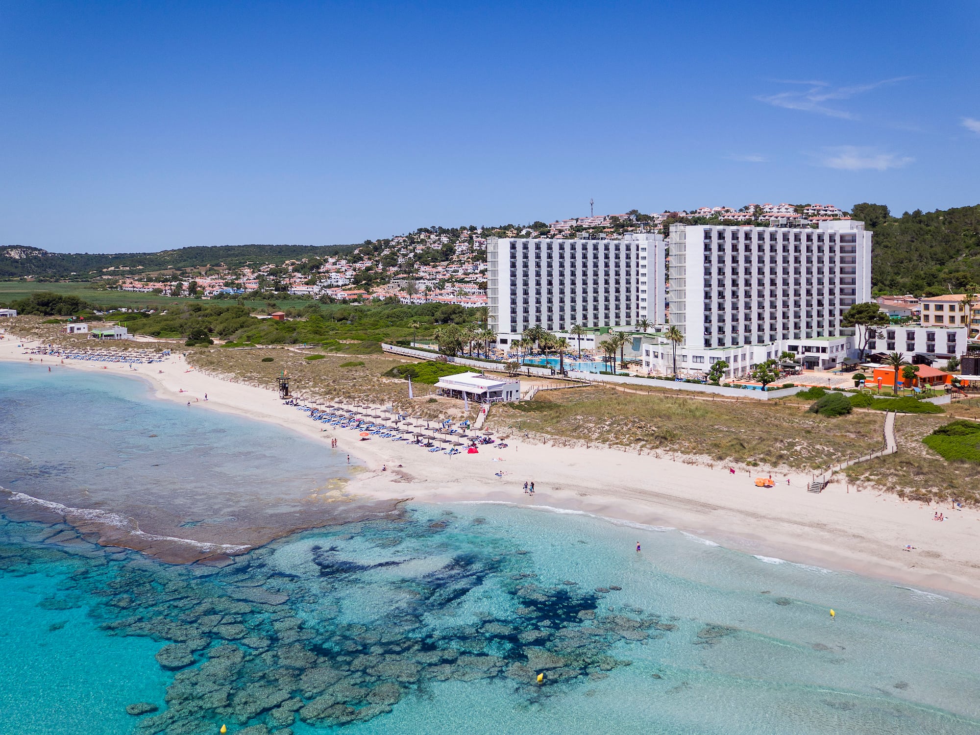a beach with a building and a body of water
