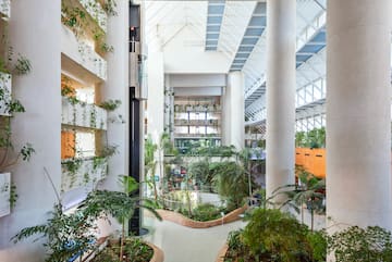 a large building with many trees and plants