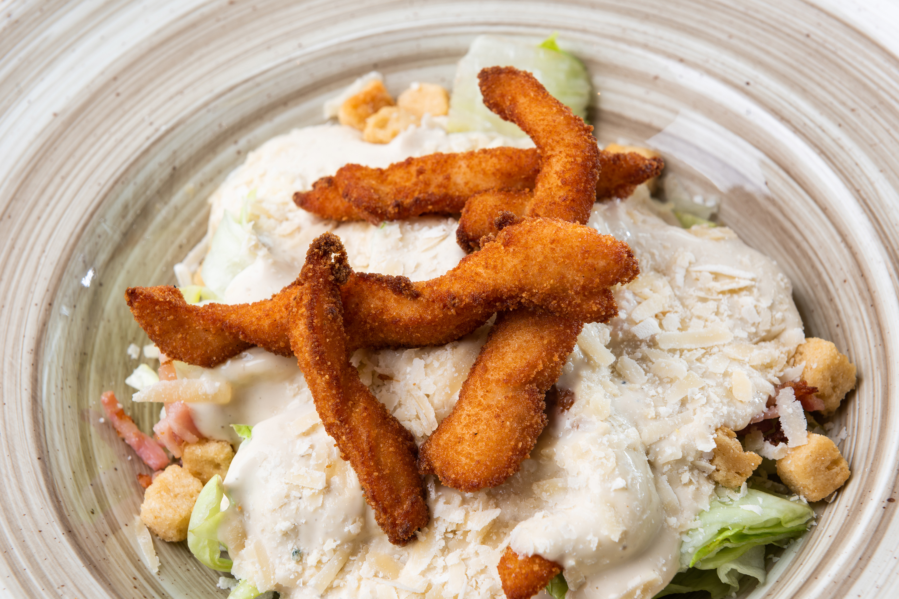 Caesar salad with crispy fried chicken, creamy dressing, parmesan, croutons.