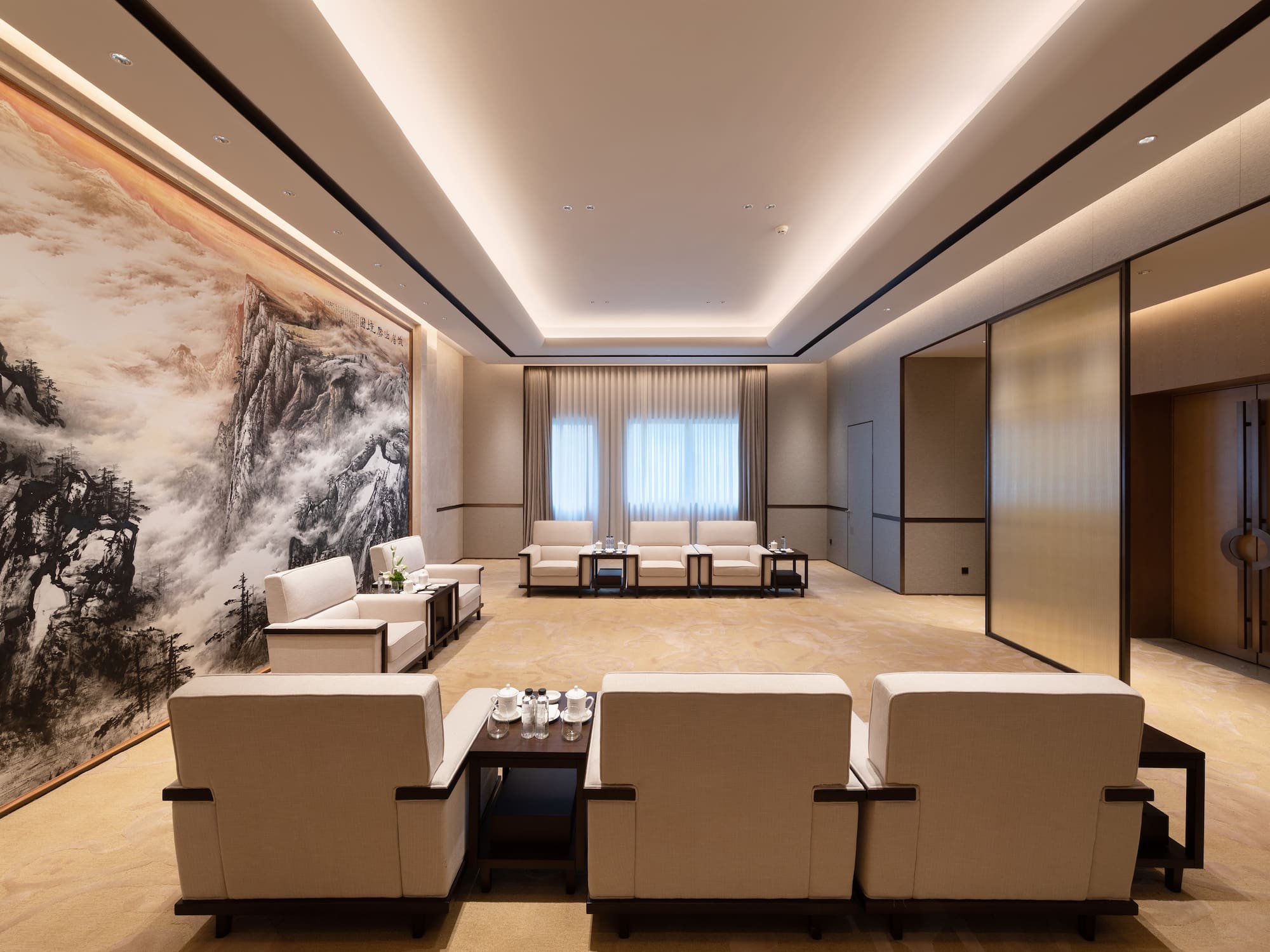 a room with white furniture and a large painting on the wall