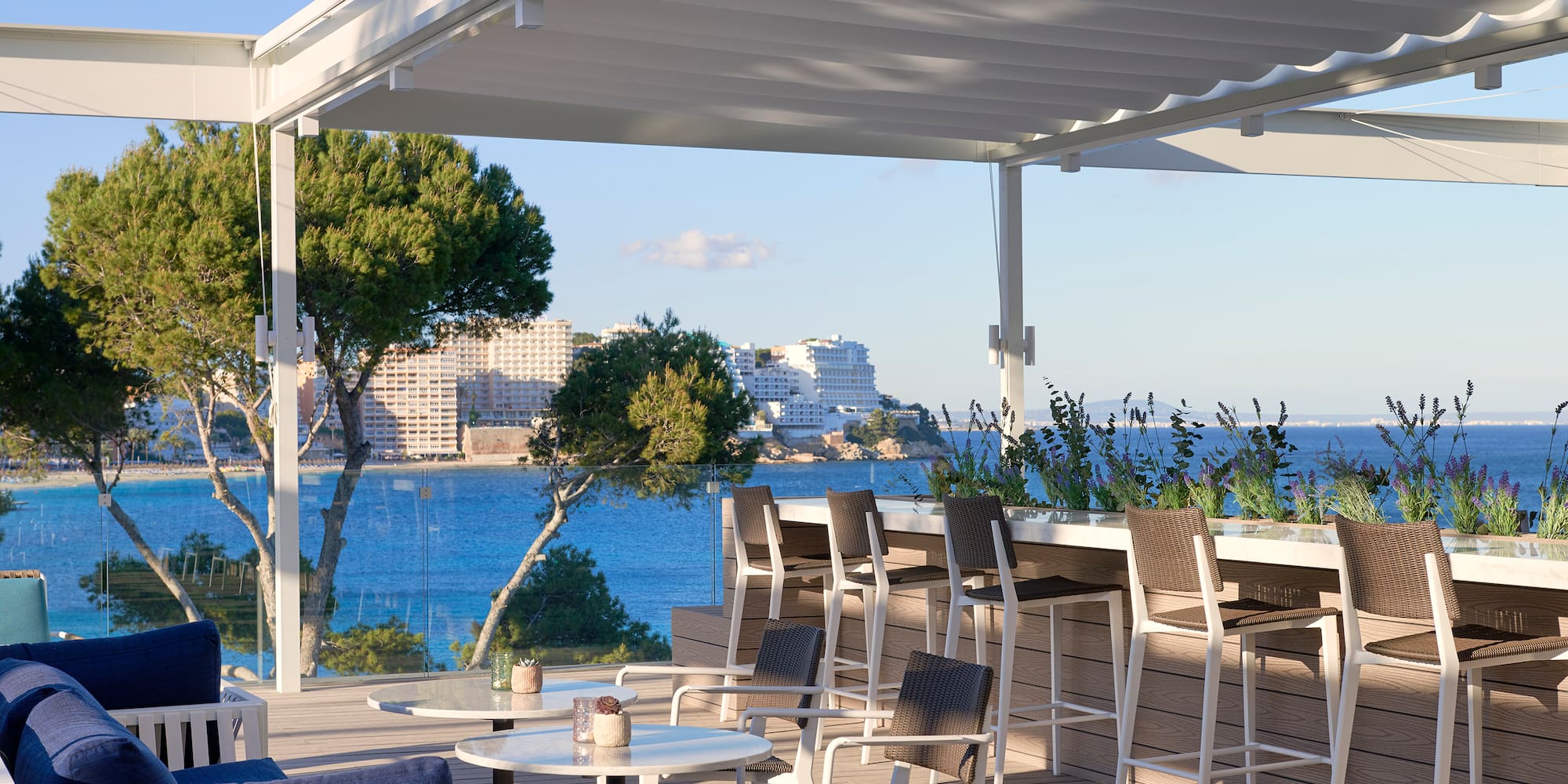 a patio with a table and chairs and a view of the water