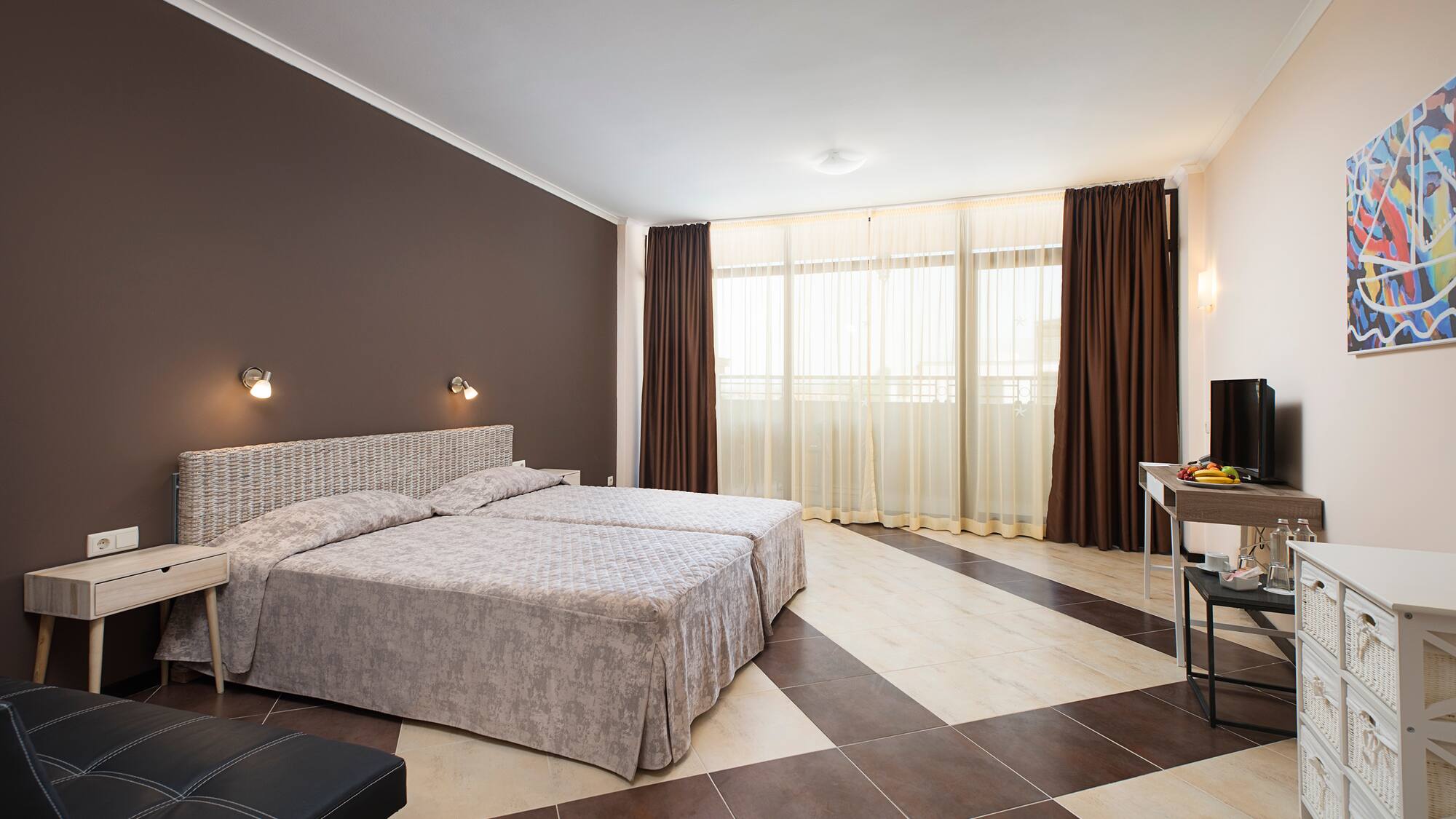 a bedroom with a checkered floor and a table and two beds