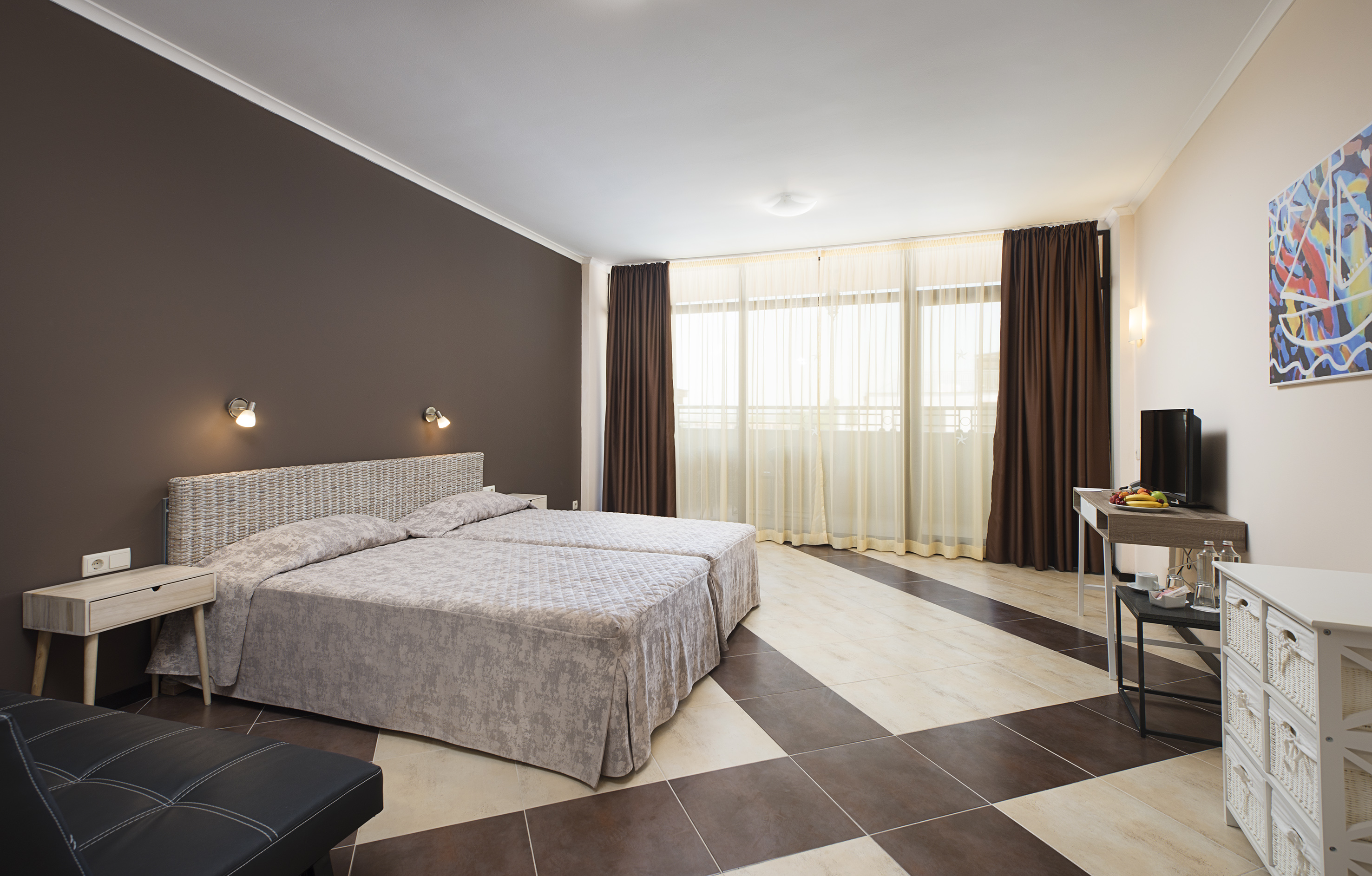 a bedroom with a checkered floor and a table and two beds