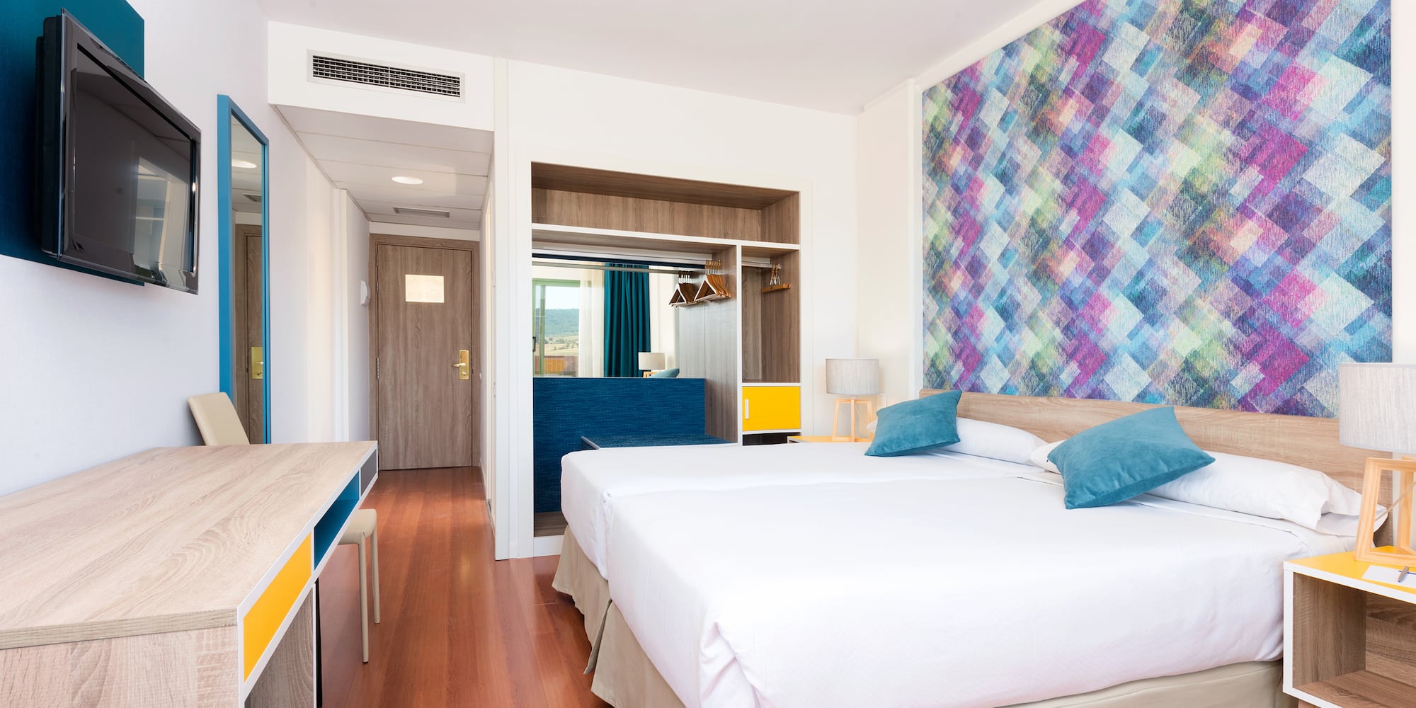 a room with two beds and a desk