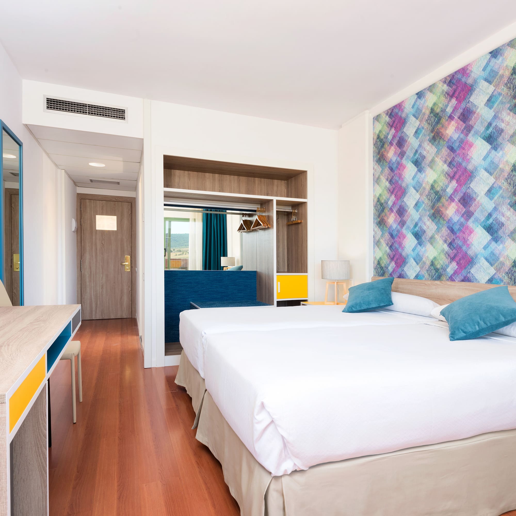 a room with two beds and a desk