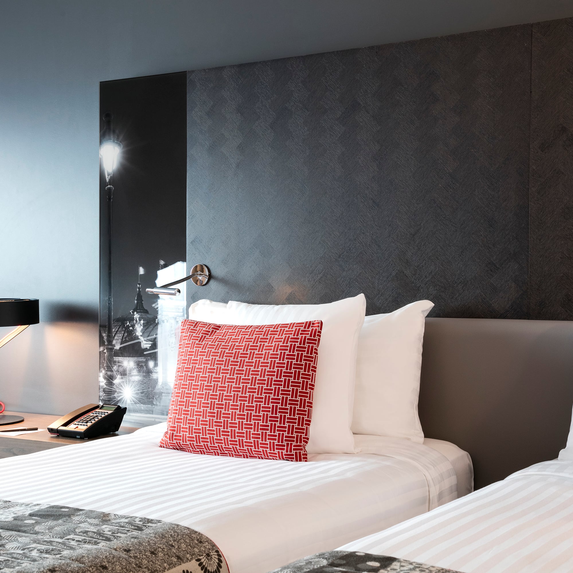 a bed with a lamp and a phone on the side