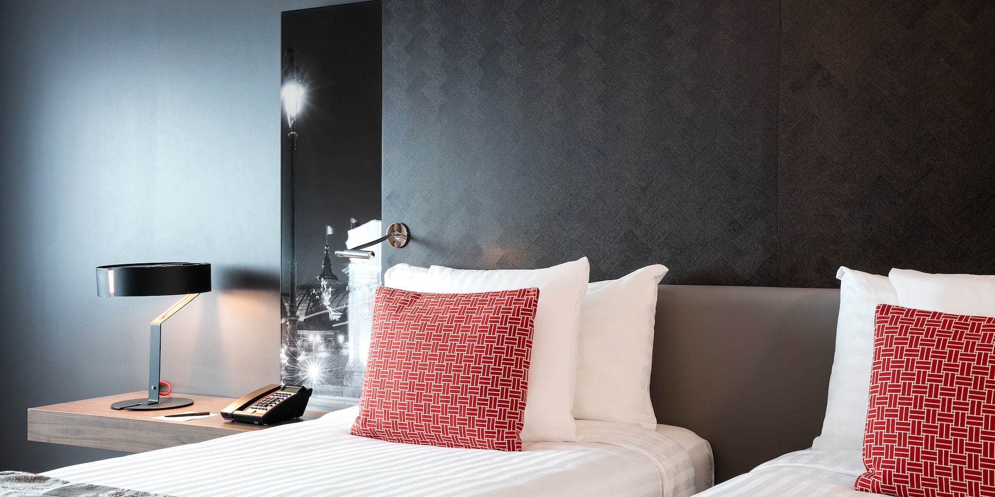 a bed with a lamp and a phone on the side