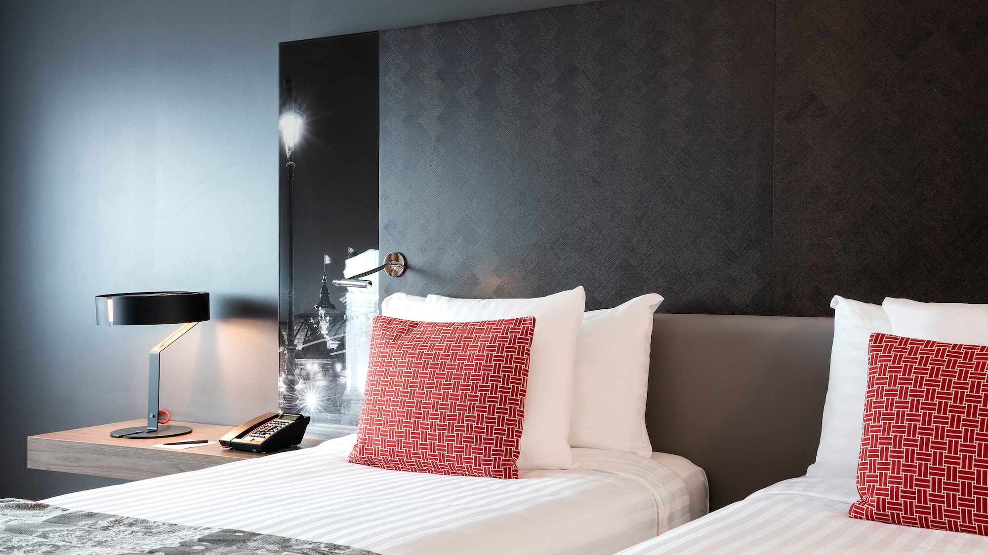 a bed with a lamp and a phone on the side