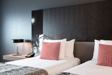 a bed with a lamp and a phone on the side