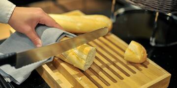 a person cutting bread on a cutting board