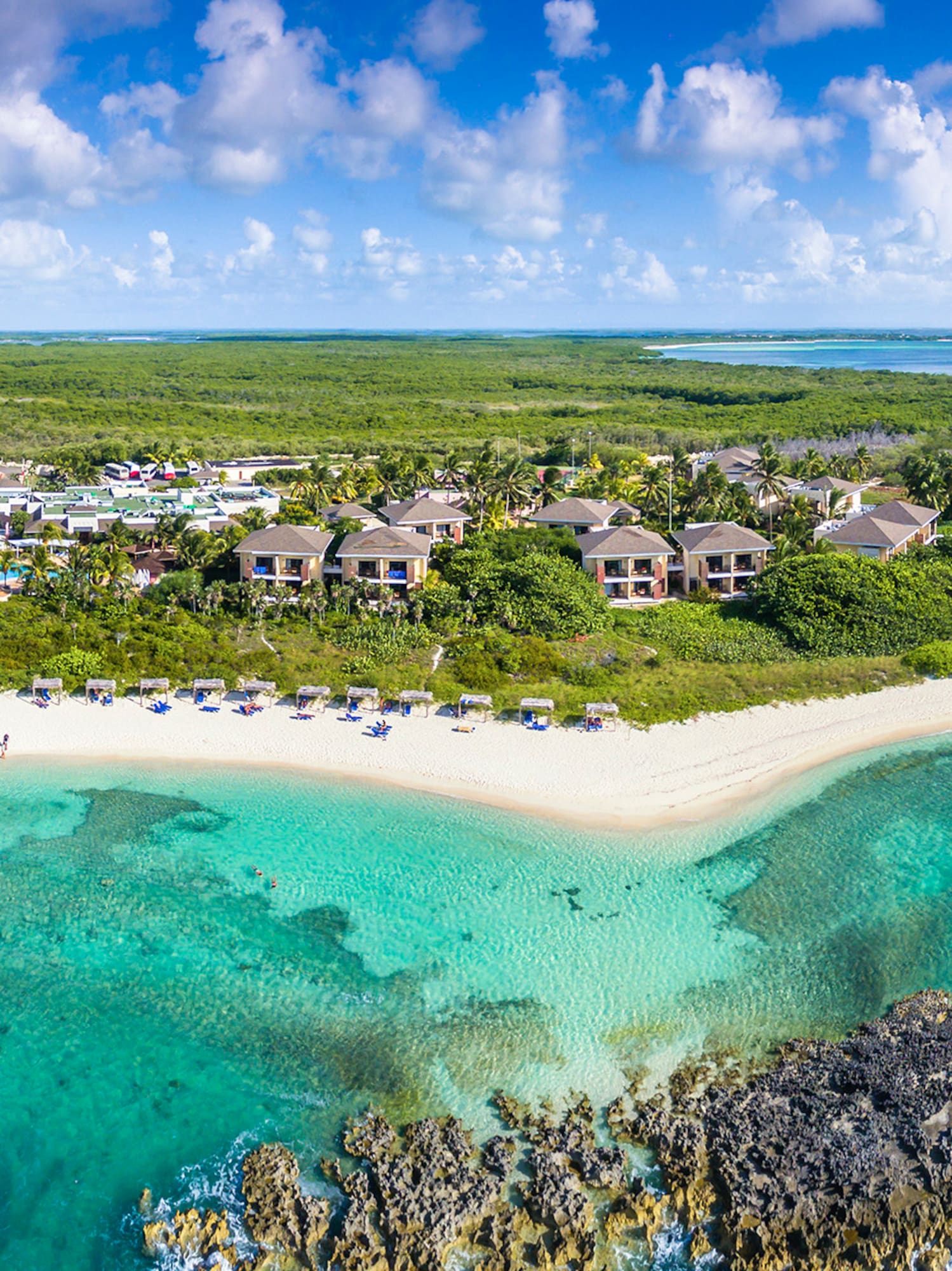a beach with buildings and blue water