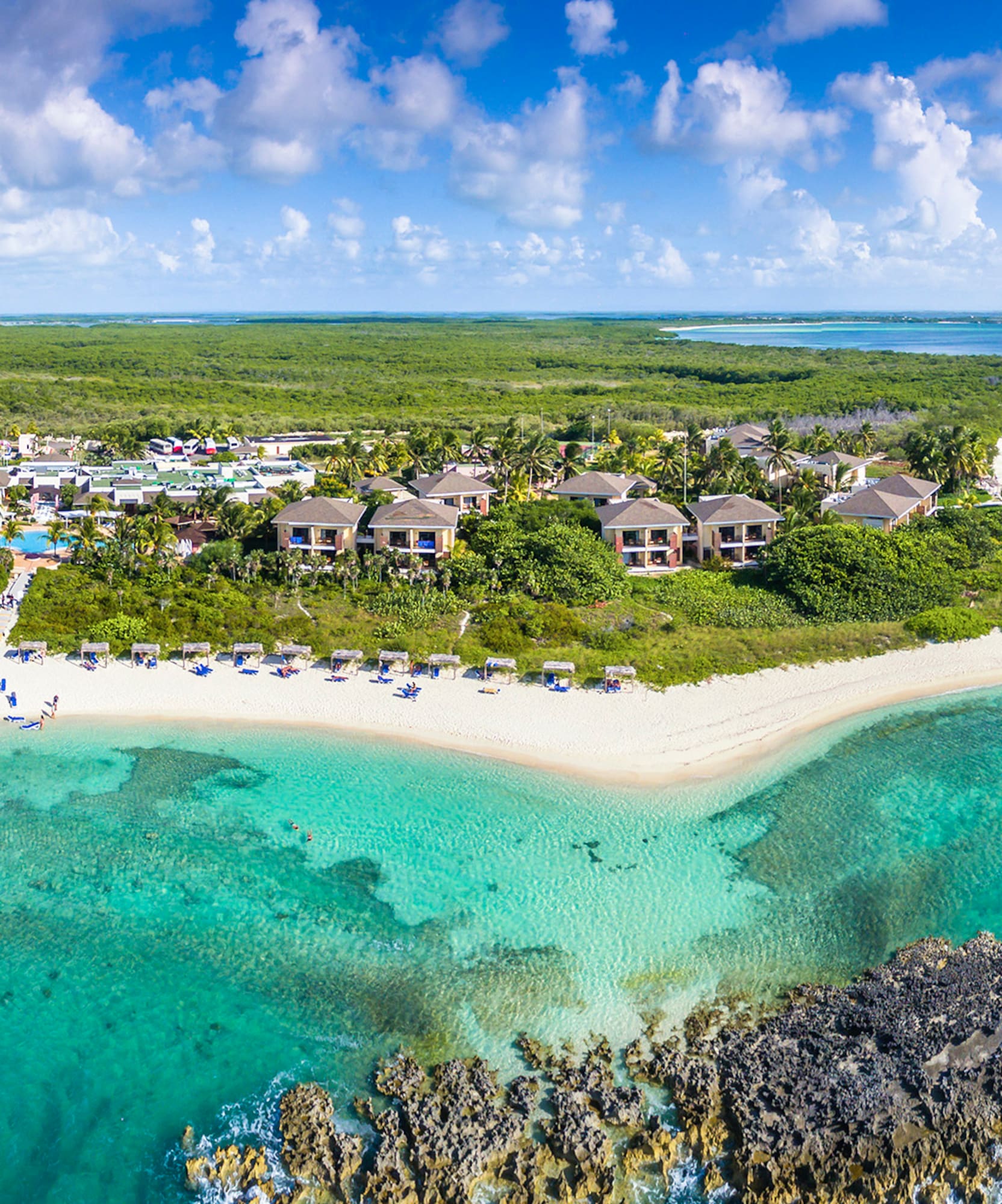a beach with buildings and blue water