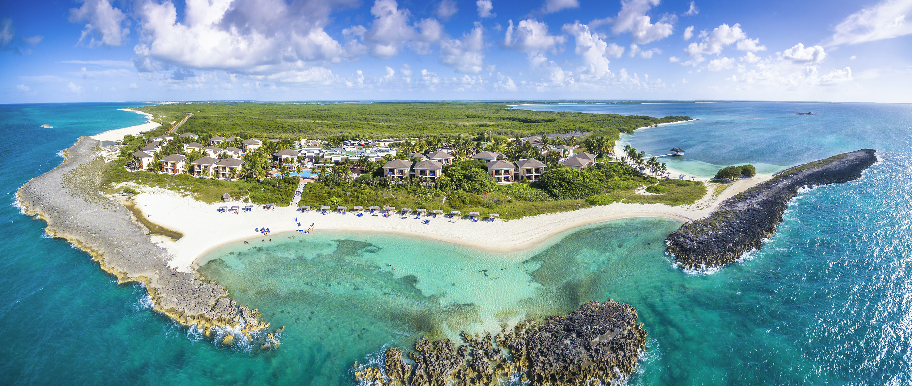 a beach with buildings and blue water