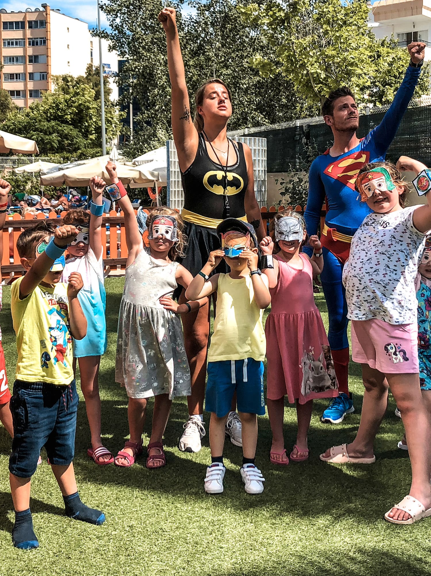 a group of people standing on grass with their arms raised