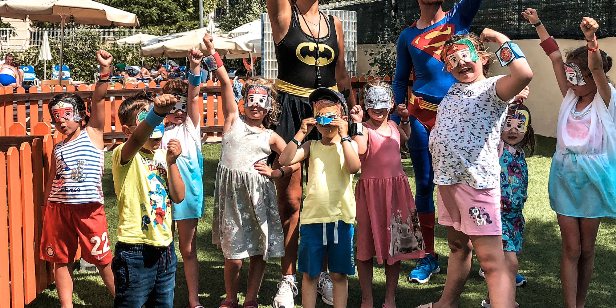 a group of people standing on grass with their arms raised