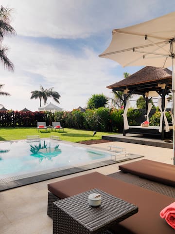 a pool with a gazebo and lounge chairs